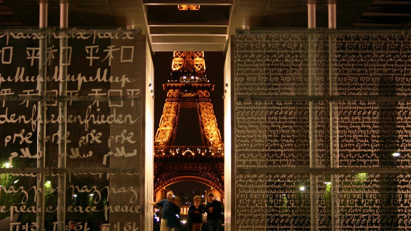 La tour Eiffel de nuit au travers du Mur de la Paix