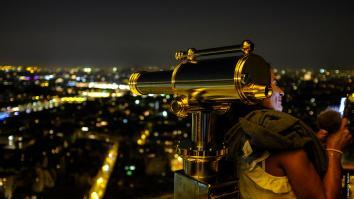 Femme avec son téléphone à la tour Eiffel de nuit