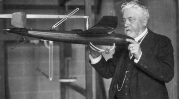 Gustave Eiffel in his laboratory holding a mock-up of a plane designed by Victor Tatin